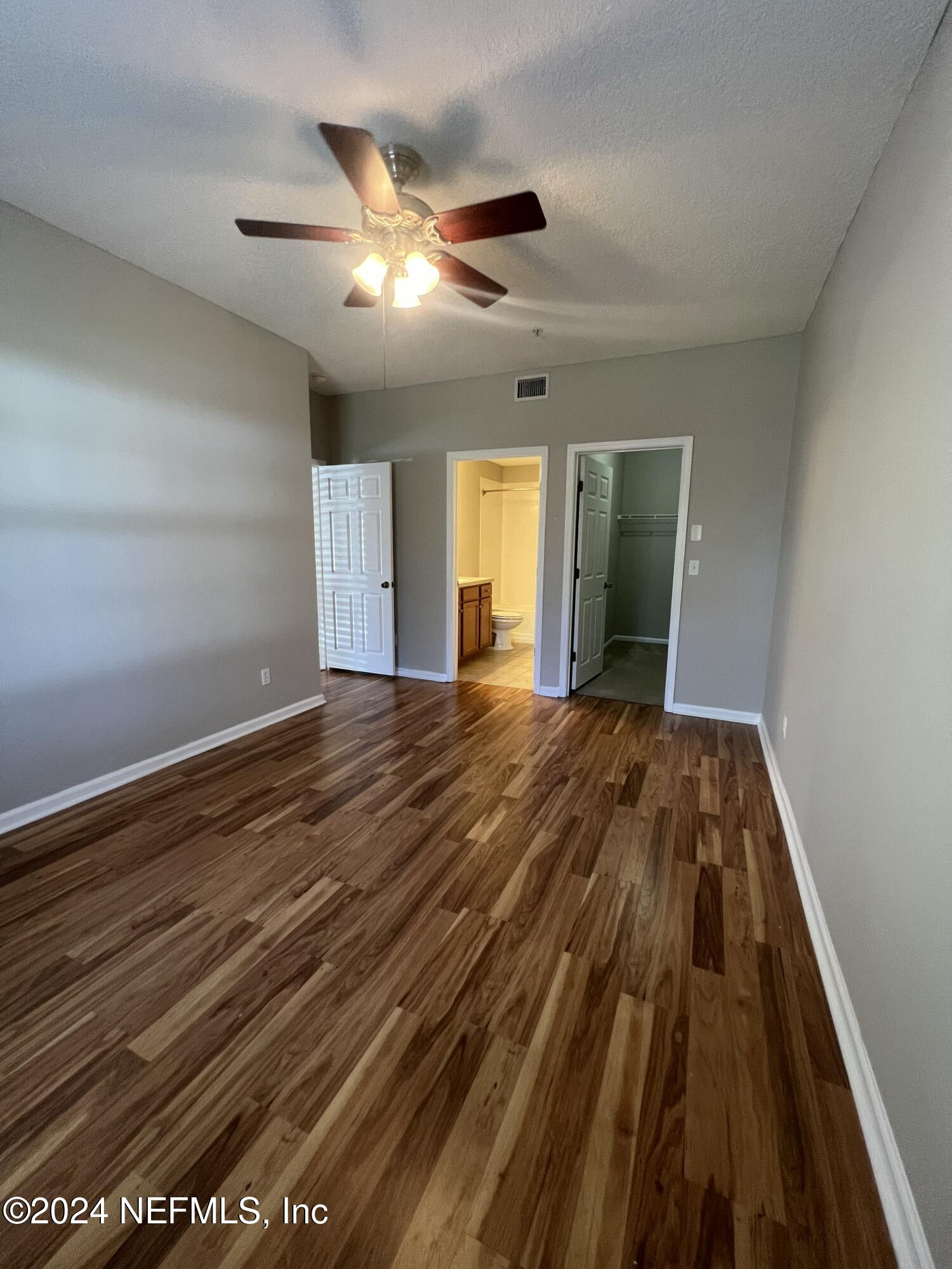 2200 Marsh Hawk Lane, Unit 604 Fleming Island, FL 32003 - Photo 14 of 19 a view of an empty room with wooden floor and a ceiling fan