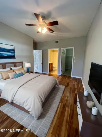 a bedroom with a bed and a flat tv screen on dresser