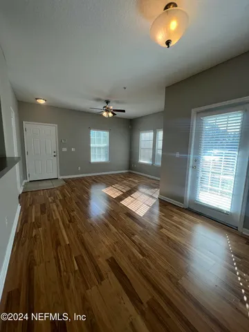 an empty room with wooden floor and windows