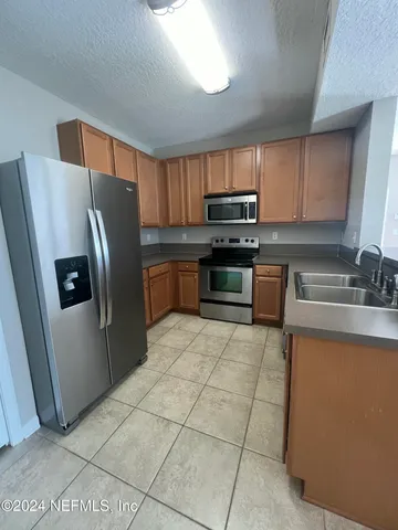 a kitchen with stainless steel appliances a refrigerator sink and microwave
