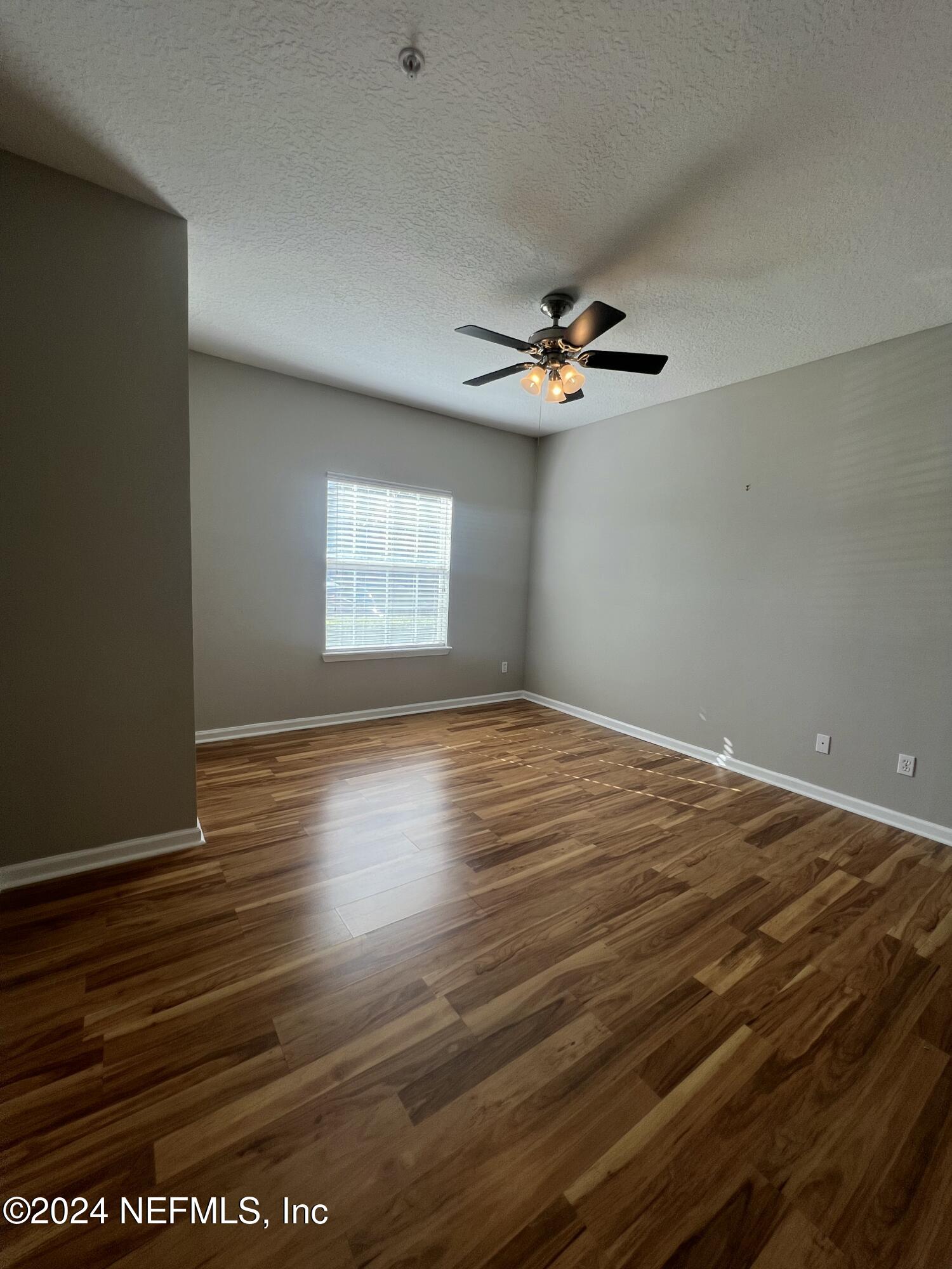 2200 Marsh Hawk Lane, Unit 604 Fleming Island, FL 32003 - Photo 8 of 19 wooden floor in an empty room with a window