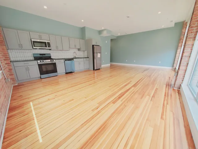 a kitchen with stainless steel appliances a refrigerator and a stove top oven