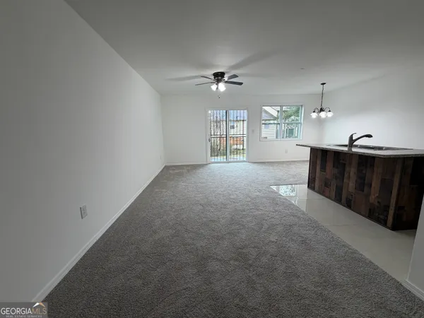 en empty room with windows and ceiling fan