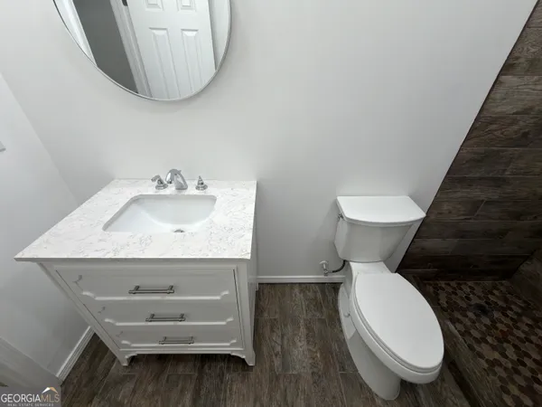 a bathroom with a toilet sink and mirror