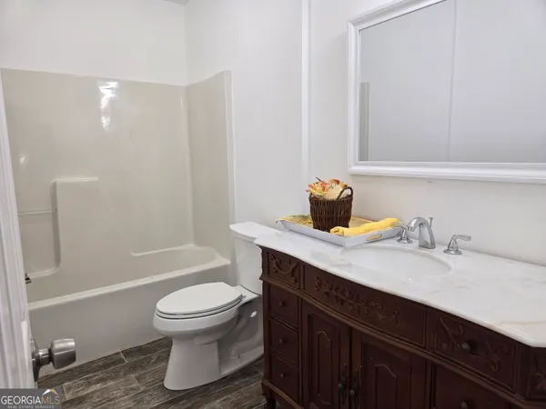 a bathroom with a granite countertop sink toilet a mirror and shower