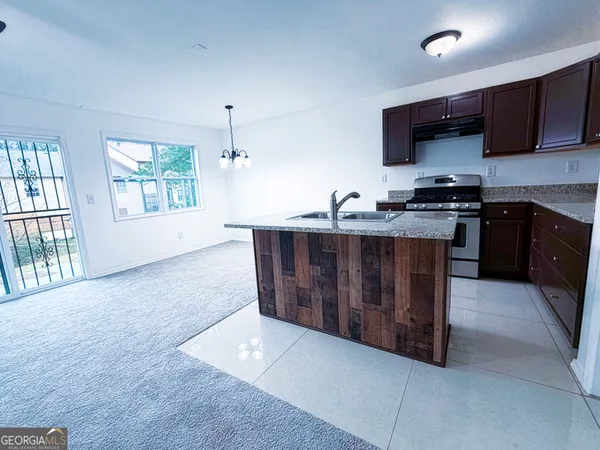 a kitchen with stainless steel appliances granite countertop a stove a sink and a microwave