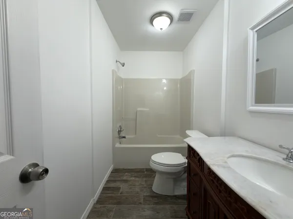 an empty room with closet area and mirror