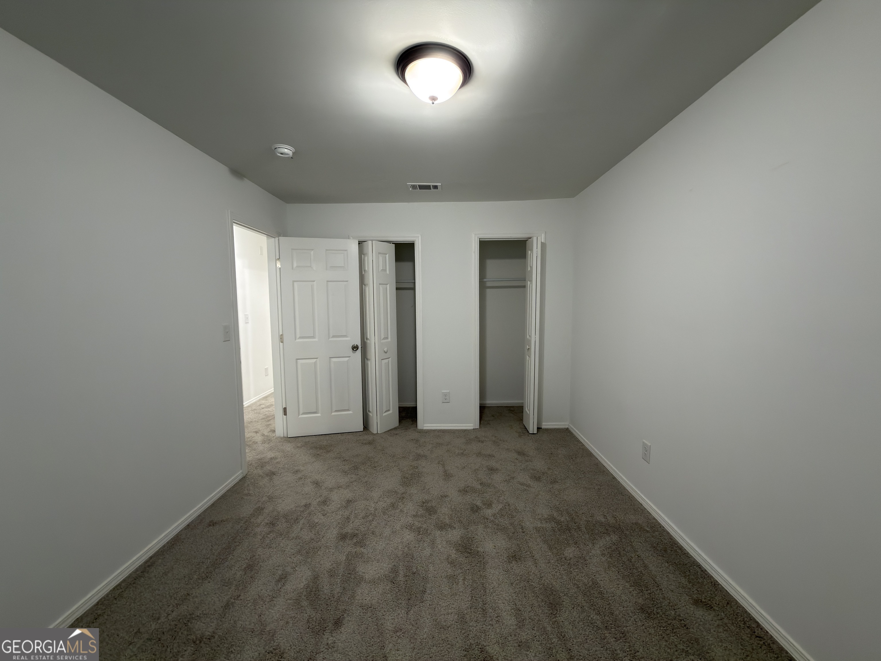 2113 Pine Tree Trail South Fulton, GA 30349 - Photo 22 of 49 an empty room with closet area and mirror