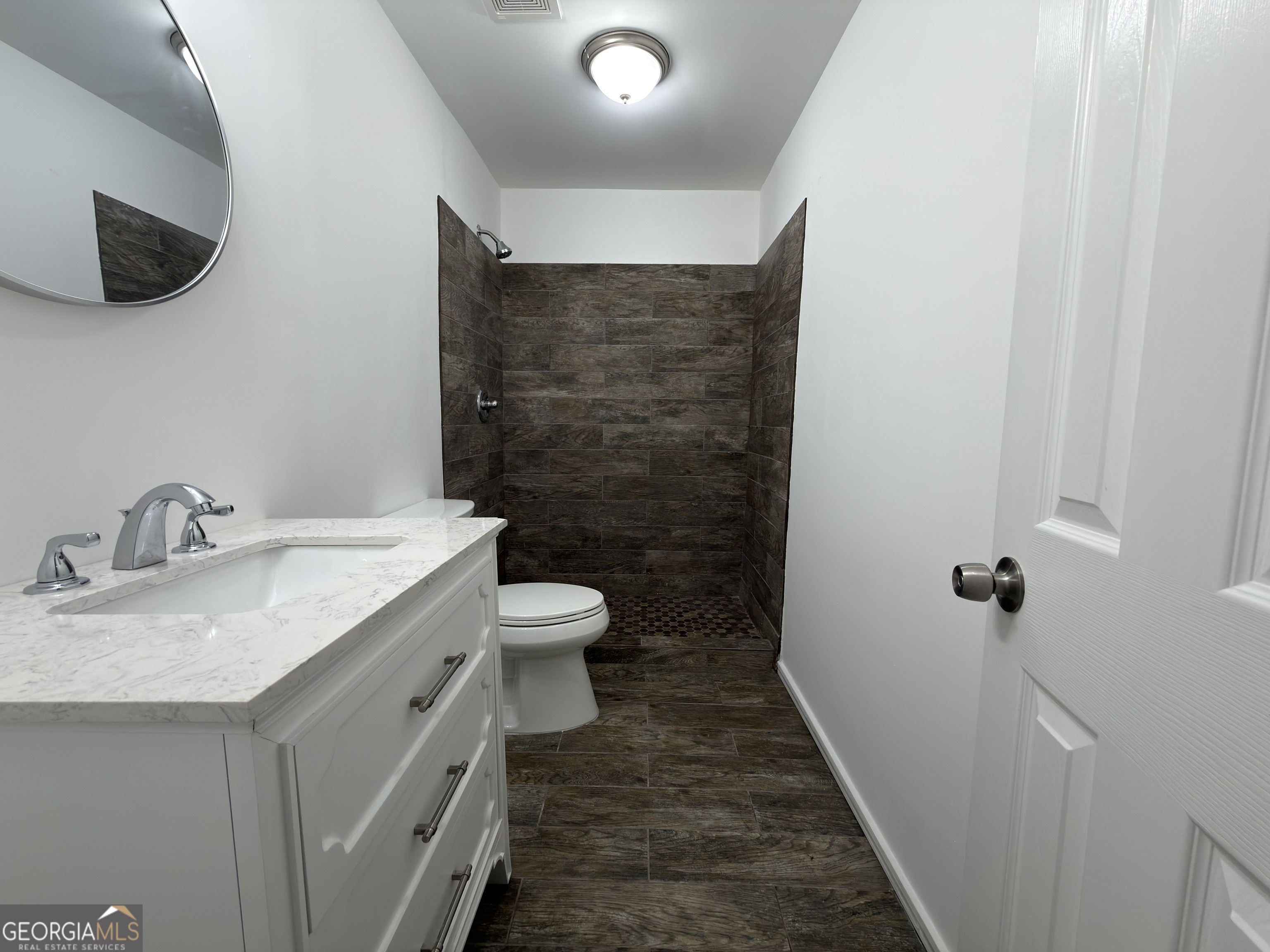 2113 Pine Tree Trail South Fulton, GA 30349 - Photo 29 of 49 a bathroom with a granite countertop sink a toilet and a mirror