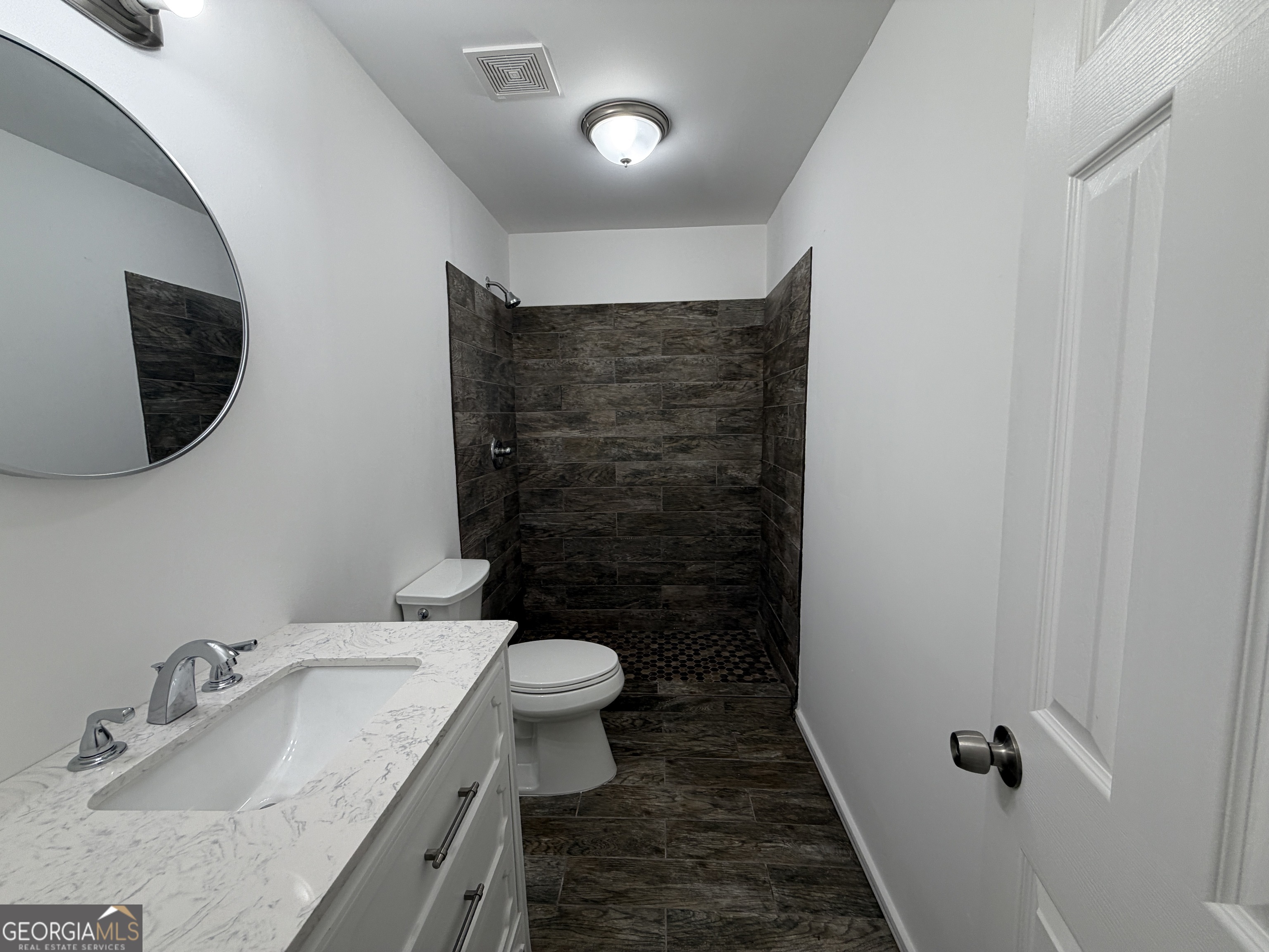 2113 Pine Tree Trail South Fulton, GA 30349 - Photo 30 of 49 a bathroom with a granite countertop sink a toilet a mirror and shower