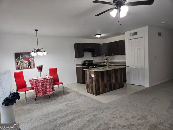 a kitchen with stainless steel appliances kitchen island granite countertop a stove and a sink