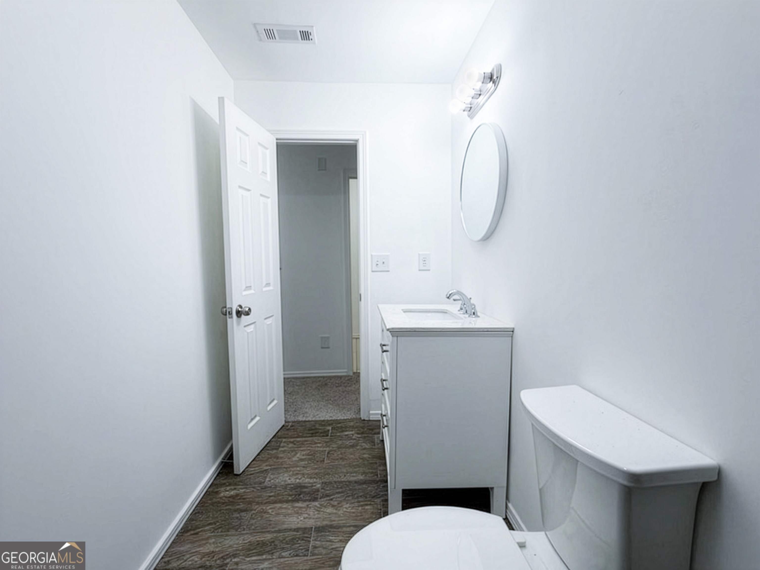 2113 Pine Tree Trail South Fulton, GA 30349 - Photo 31 of 49 a bathroom with a toilet a sink and mirror