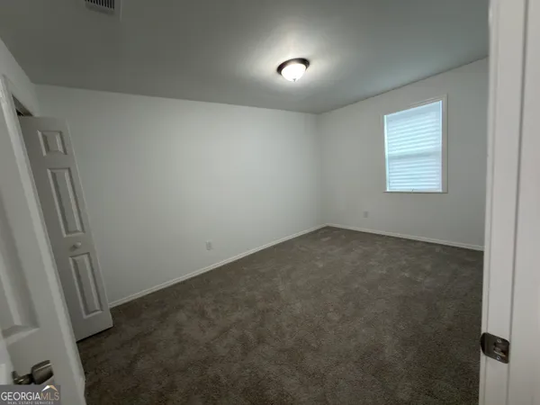 a bathroom with a shower and a white door
