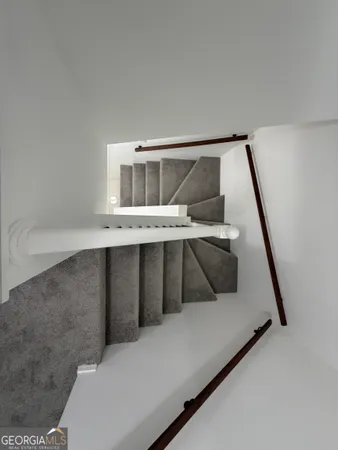 a view of a white house with a large space in front of it