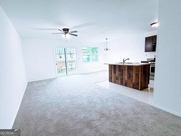 an empty room with windows and ceiling fan