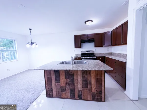 a kitchen that has a microwave a stove and a sink
