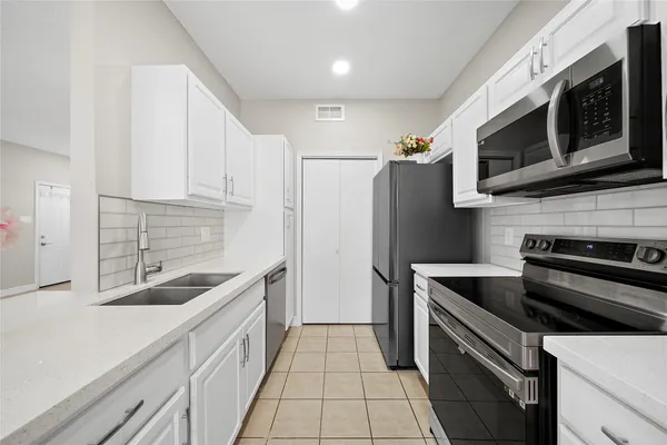 a kitchen with stainless steel appliances granite countertop a refrigerator and a sink