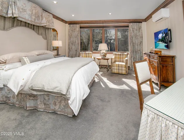 a spacious bedroom with a bed and large windows