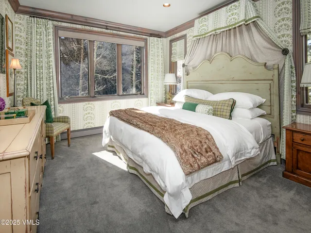 a bedroom with a bed lamp and a large window