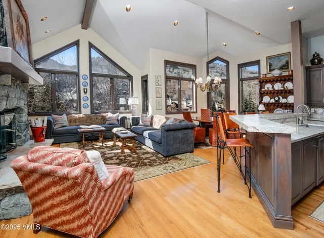 a living room with furniture a large window and a chandelier