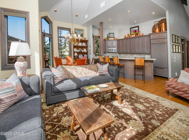 a living room with lots of furniture and view of kitchen