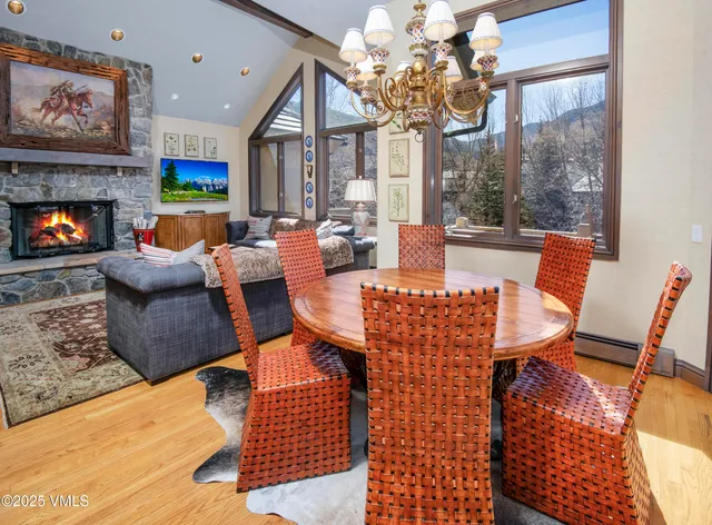 a dining room with furniture a large window and a fireplace
