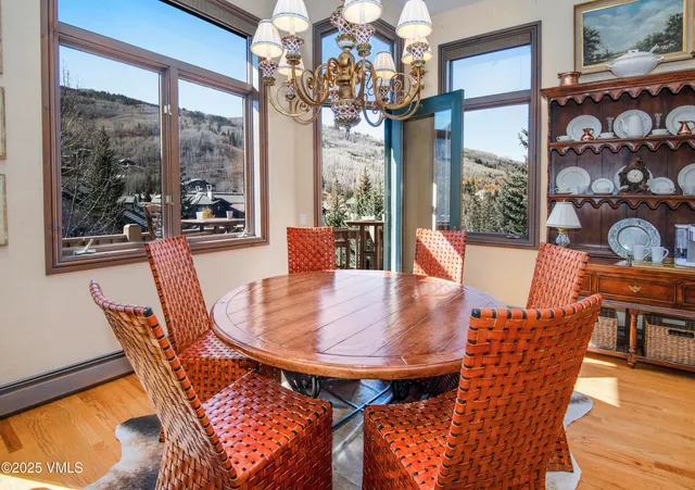 a dining room with furniture a chandelier and wooden floor