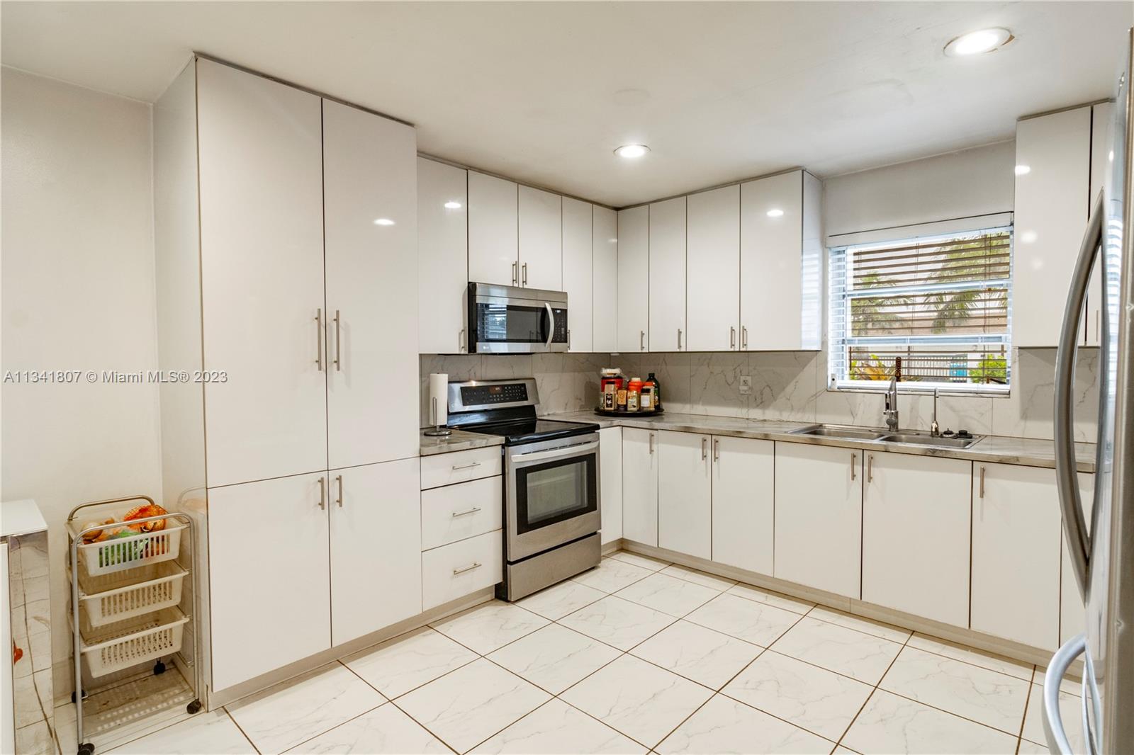 16041 Southwest 284th Street Homestead, FL 33033 - Photo 5 of 20 a kitchen with granite countertop white cabinets and white appliances