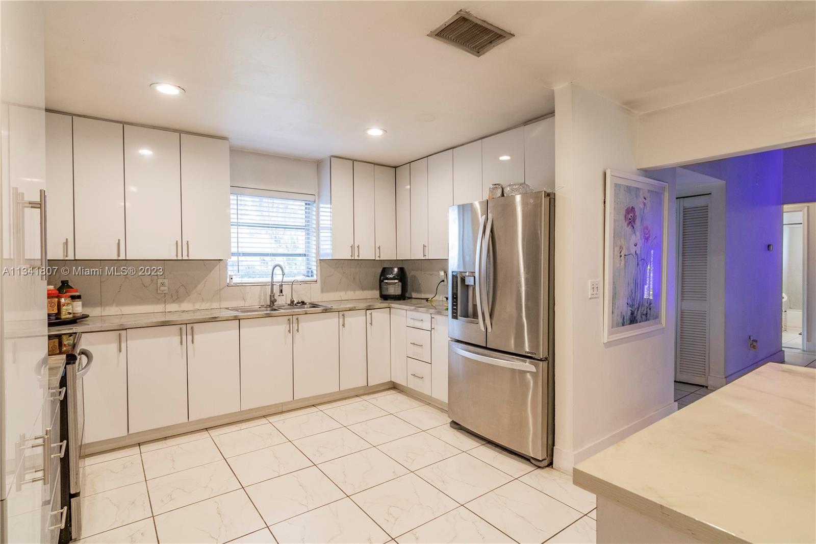 16041 Southwest 284th Street Homestead, FL 33033 - Photo 6 of 20 a kitchen with granite countertop stainless steel appliances a refrigerator sink and microwave