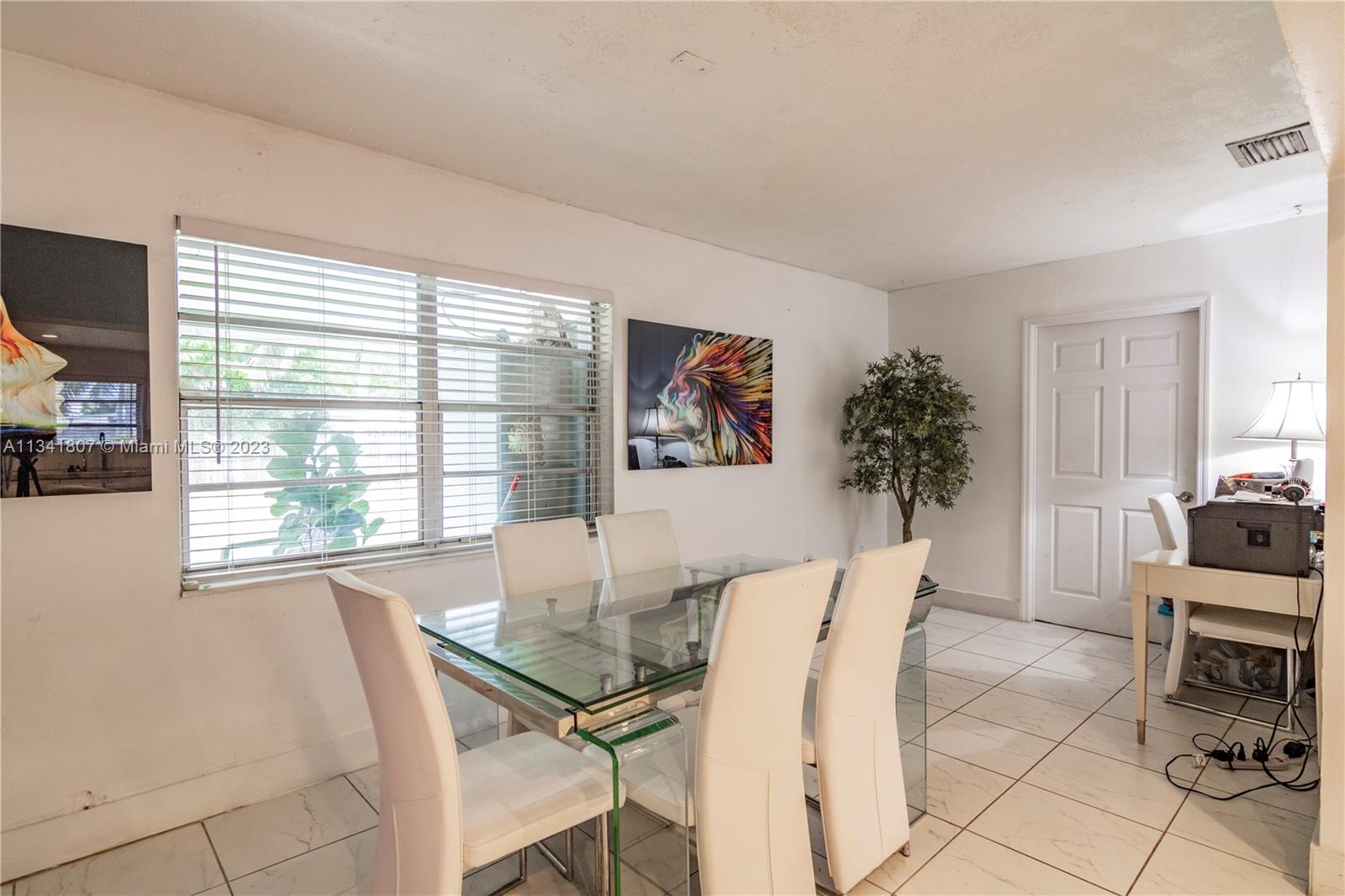 16041 Southwest 284th Street Homestead, FL 33033 - Photo 7 of 20 a view of a dining room with furniture and a potted plant