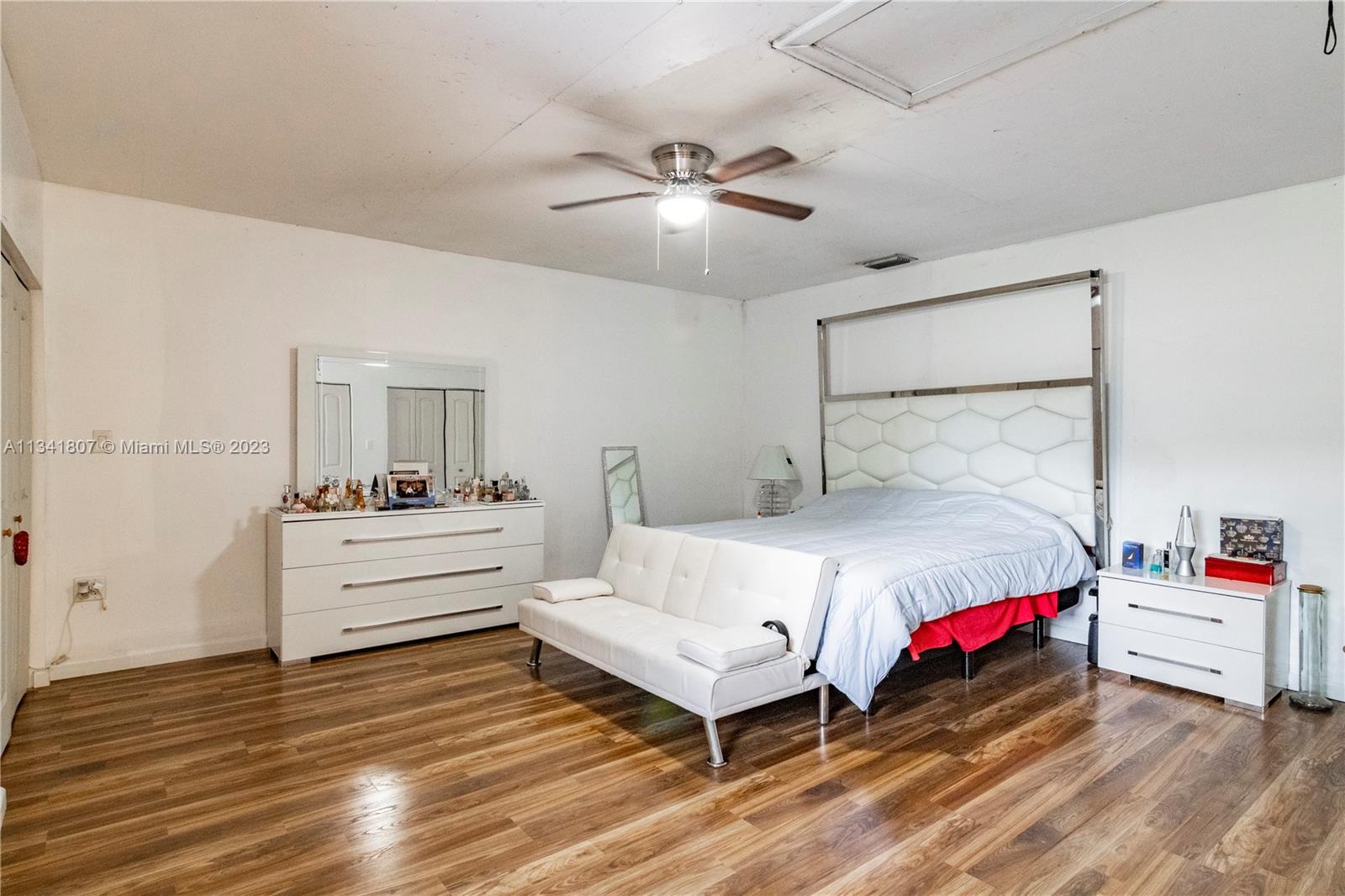 16041 Southwest 284th Street Homestead, FL 33033 - Photo 8 of 20 a bedroom with a bed and a chandelier