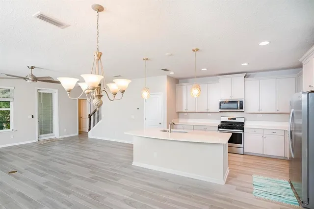 a kitchen with granite countertop white cabinets and stainless steel appliances