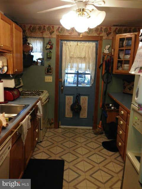 8286 Mission Road Jessup, MD 20794 - Photo 3 of 8 a kitchen with a stove a refrigerator and a fireplace
