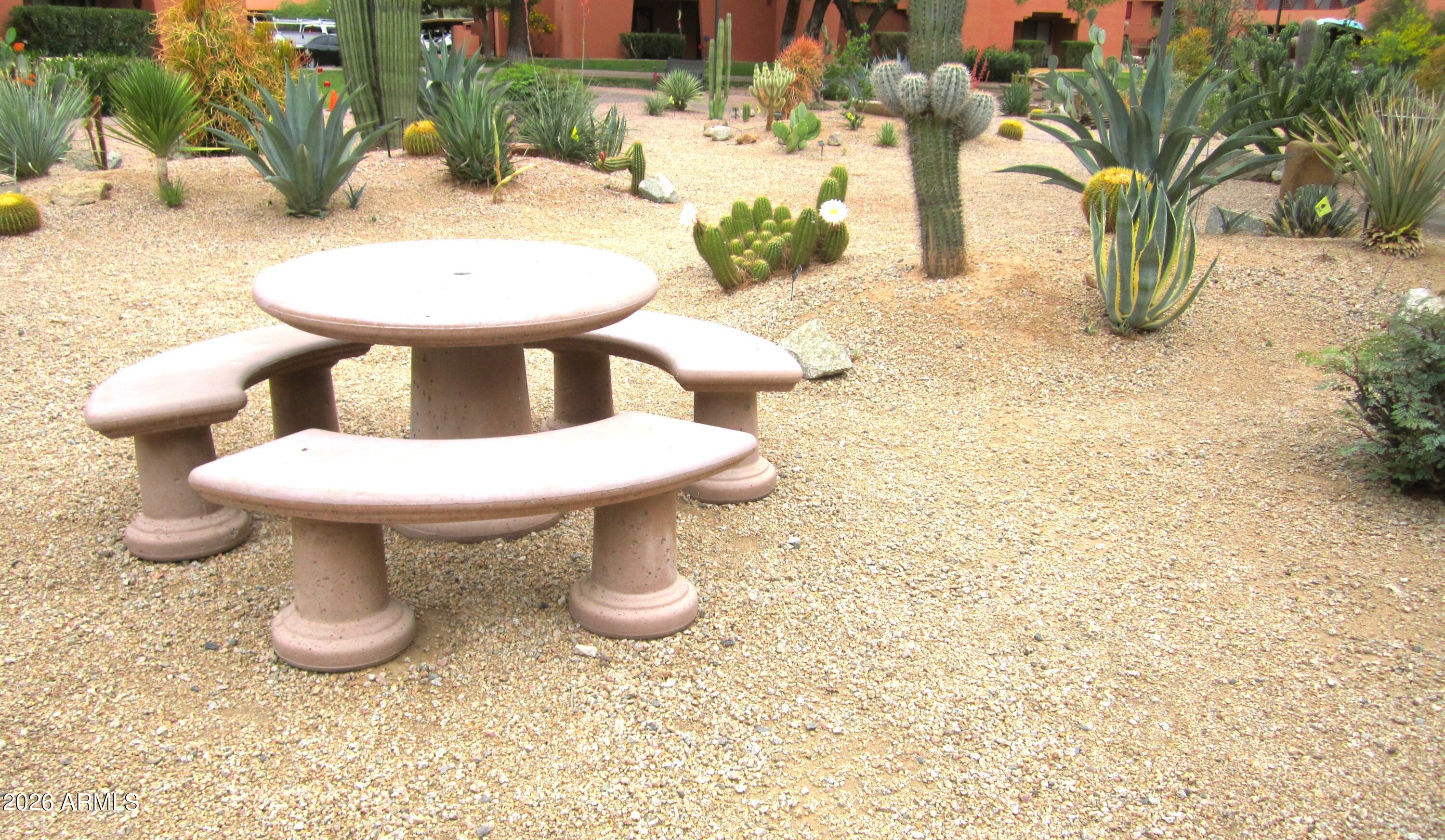 4303 East Cactus Road, Unit 419 Phoenix, AZ 85032 - Photo 11 of 13 ANASAZI 2025 SEATING AREA AMONG BLOOMING