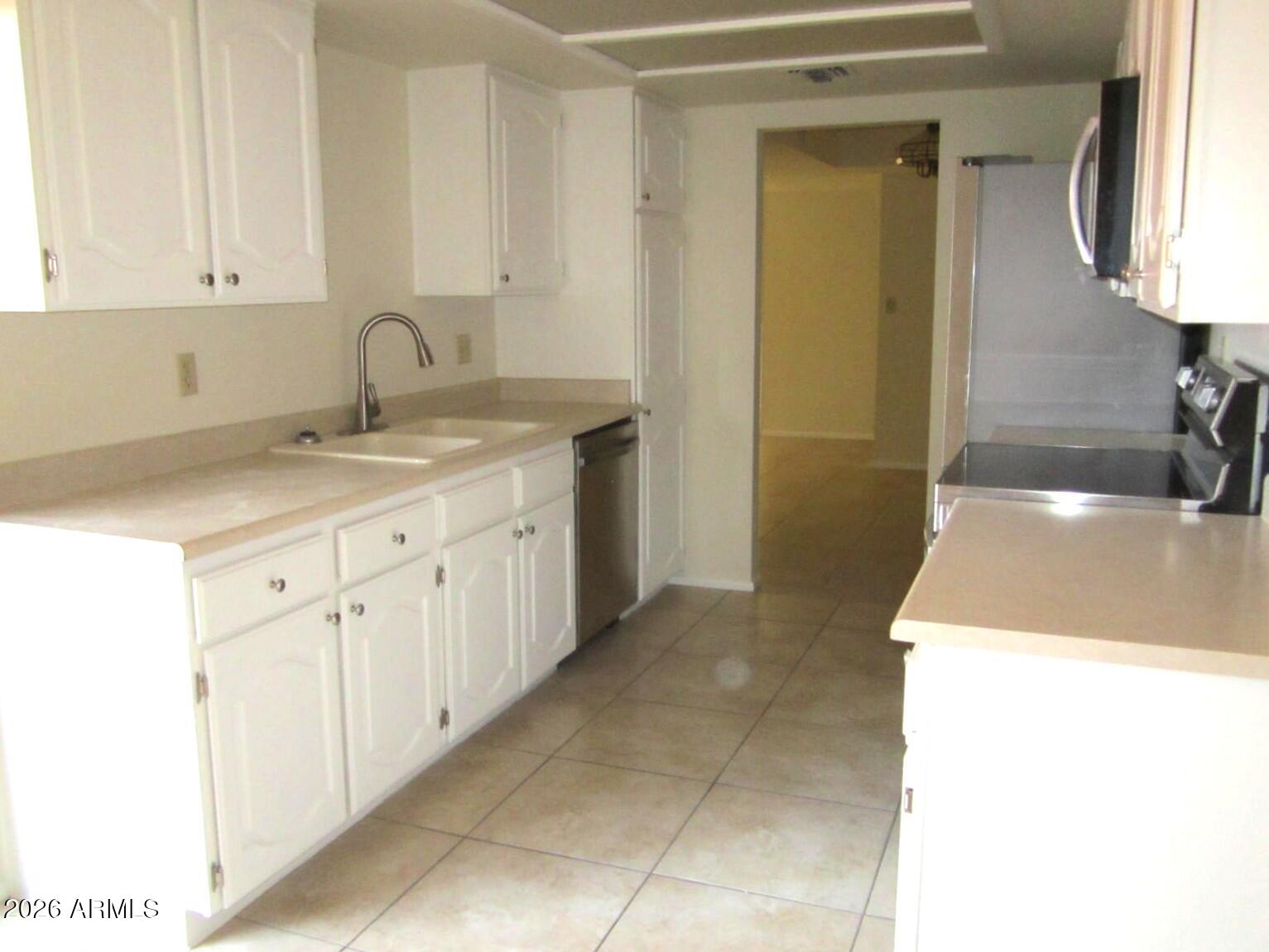 4303 East Cactus Road, Unit 419 Phoenix, AZ 85032 - Photo 2 of 34 a kitchen with a sink and cabinets