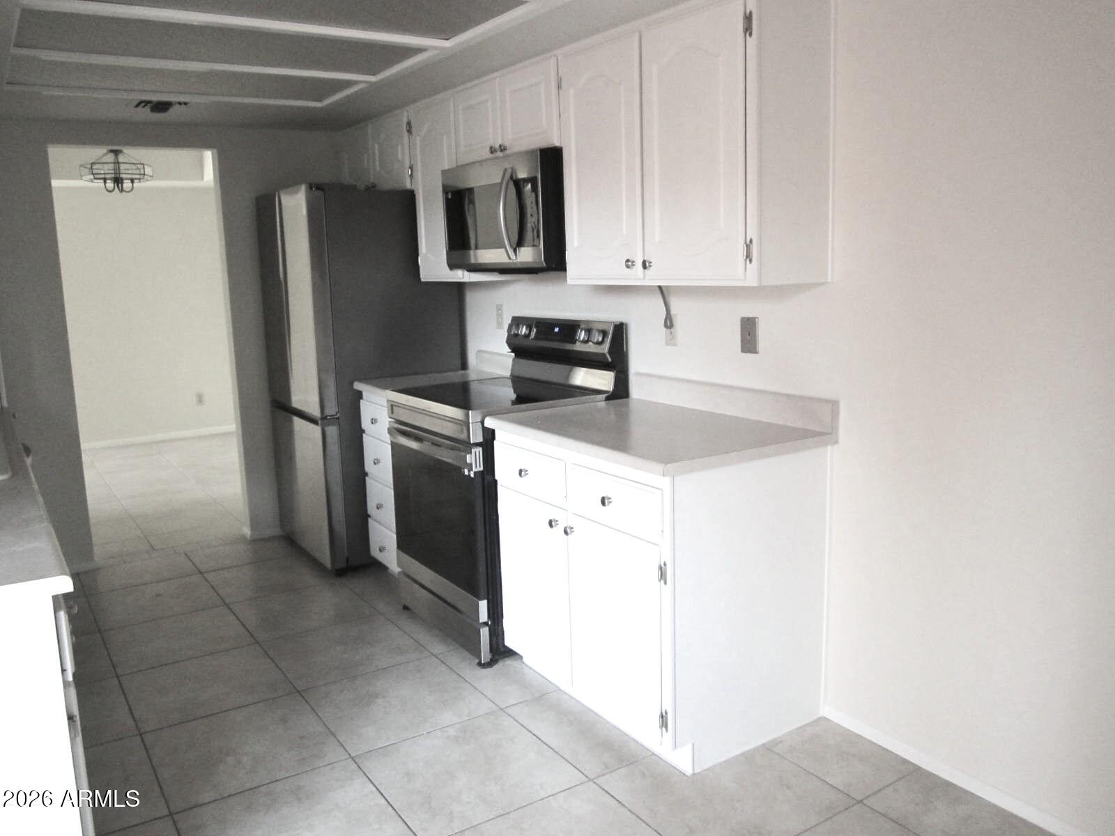 4303 East Cactus Road, Unit 419 Phoenix, AZ 85032 - Photo 5 of 34 a kitchen with a refrigerator sink and cabinets