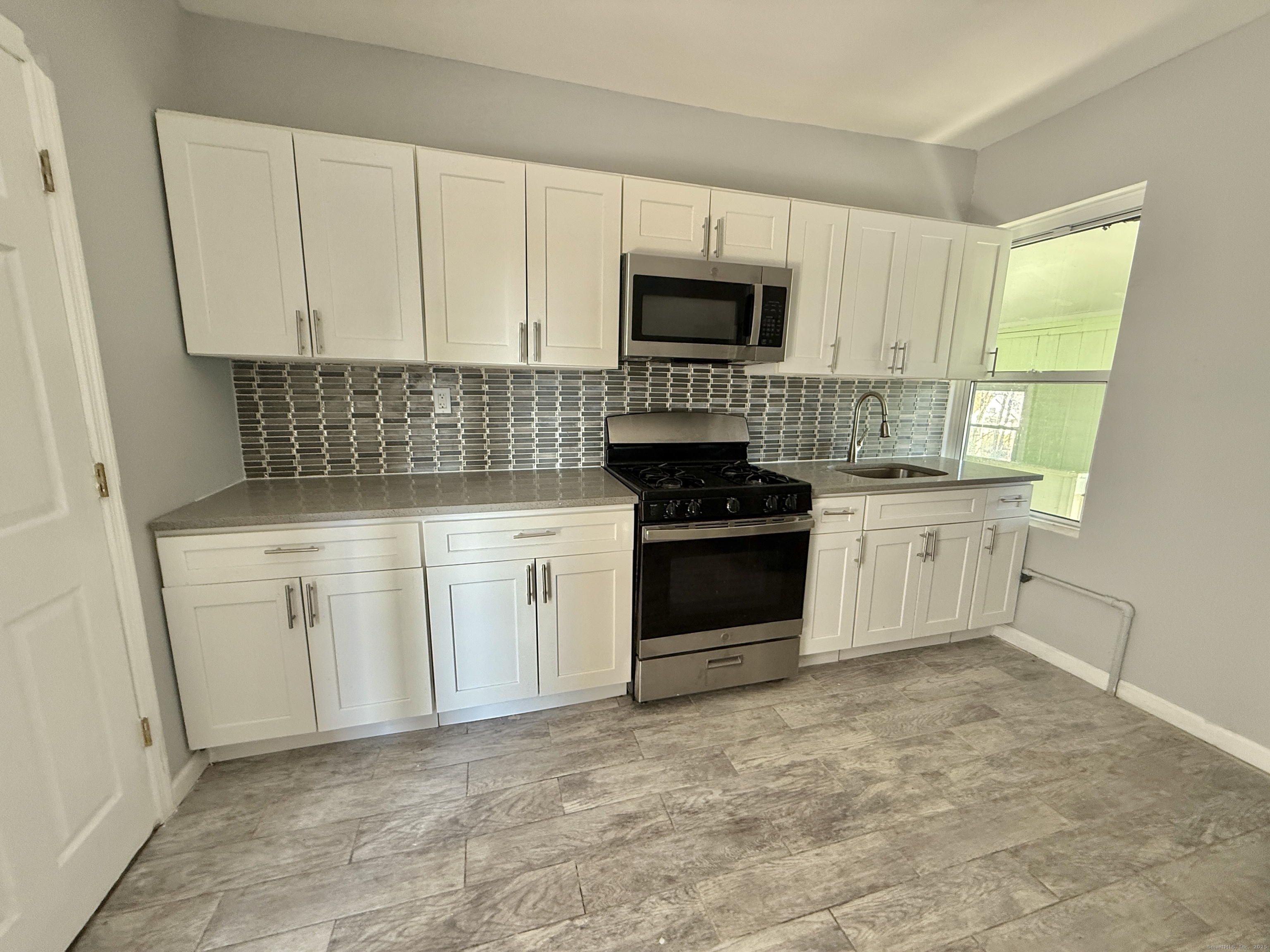1220 Pembroke Street, Unit 3R Bridgeport, CT 06608 - Photo 3 of 8 a kitchen with white cabinets and appliances