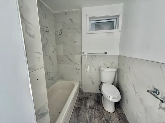 a white toilet sitting next to a bathroom sink and a shower