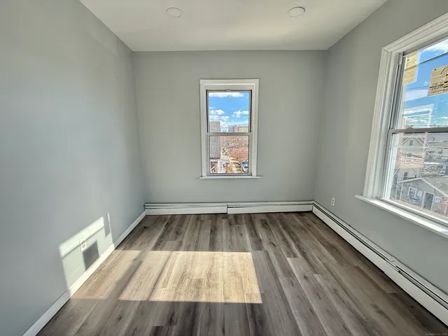 a view of wooden floor in an empty room with a window