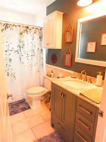 a bathroom with a granite countertop sink mirror vanity and toilet