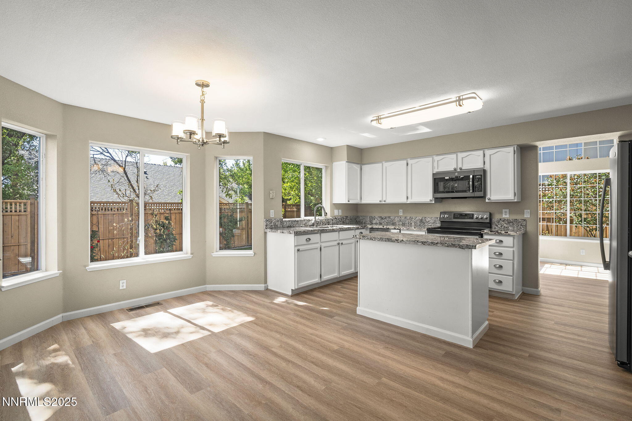 5830 Blue Horizon Drive Reno, NV 89523 - Photo 15 of 41 a open kitchen with granite countertop a stove top oven a sink dishwasher a dining table and chairs with wooden floor
