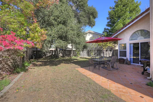 a view of a patio with a table and chairs under an umbrella