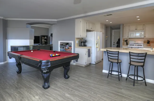 a room with pool table and wooden floor