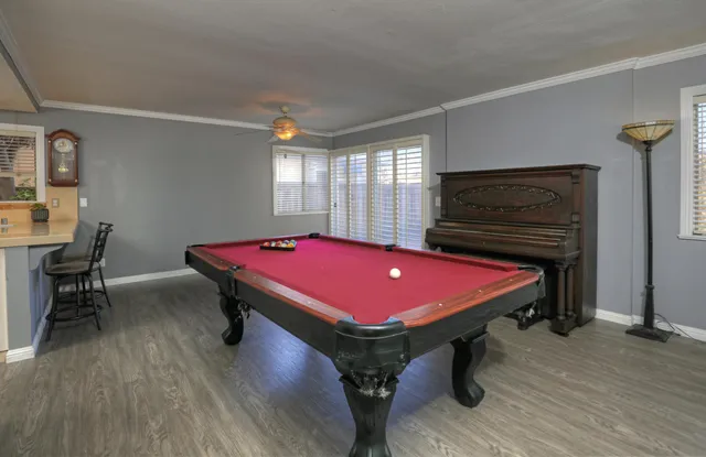 a room with pool table and windows