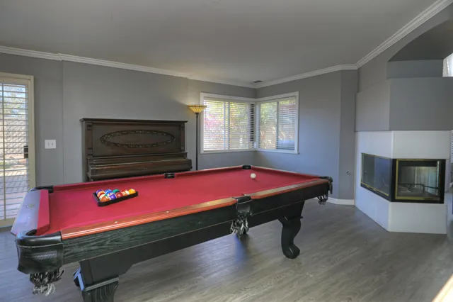 a room with pool table and windows