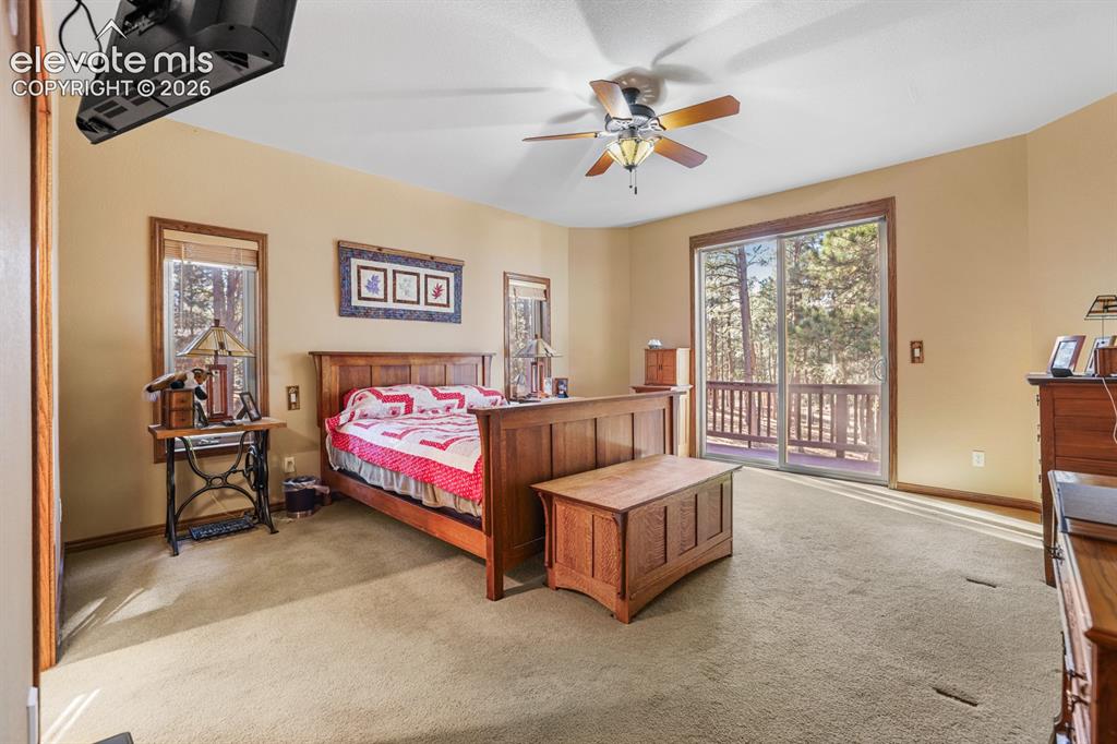 17990 Sawmill Road Colorado Springs, CO 80908 - Photo 13 of 40 Primary bedroom with glass doors to the deck