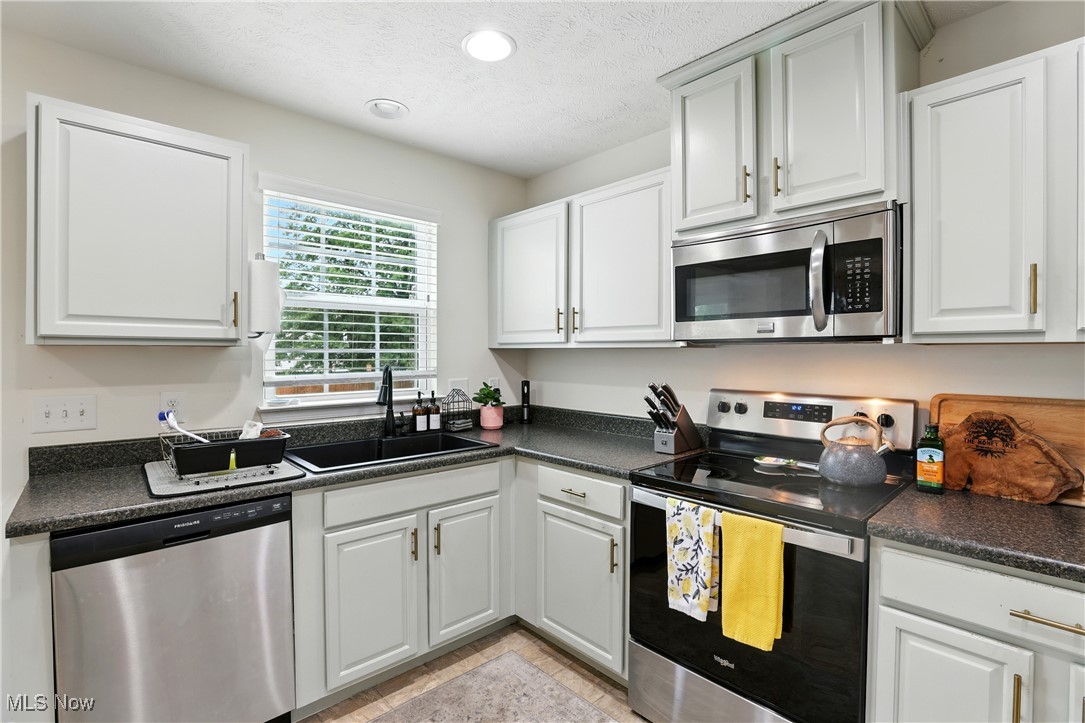2112 Fowl Road Elyria, OH 44035 - Photo 15 of 49 Kitchen with stainless steel appliances, dark countertops, white cabinetry, recessed lighting, and a textured ceiling