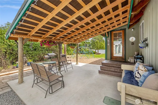 a view of a patio with a table and chairs next to a yard