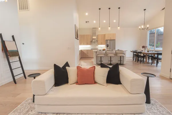a large kitchen with kitchen island a stove a sink a dining table and chairs