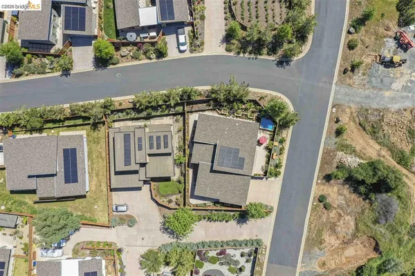 an aerial view of a house with a yard potted plants and large tree